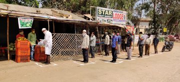 People observing physical distancing at a fruit vendor in Kerala, India.