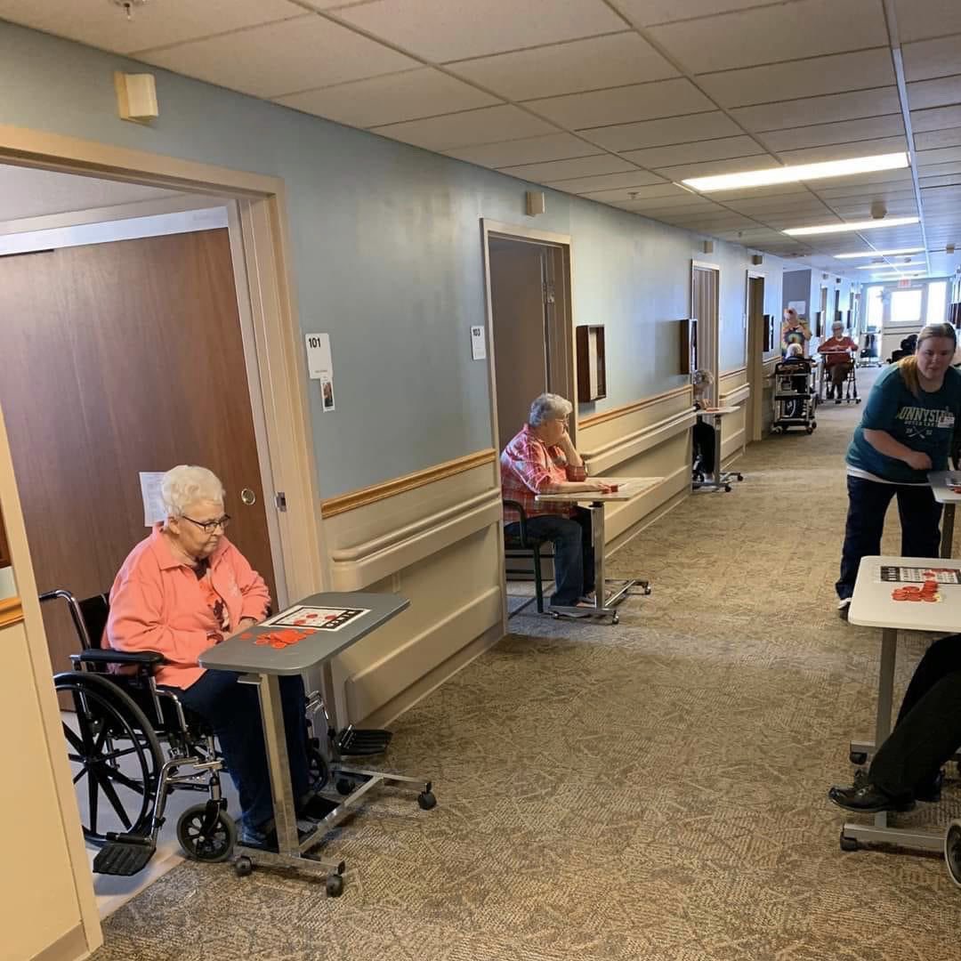 Hallway bingo at a nursing home for seniors while respecting social distancing.