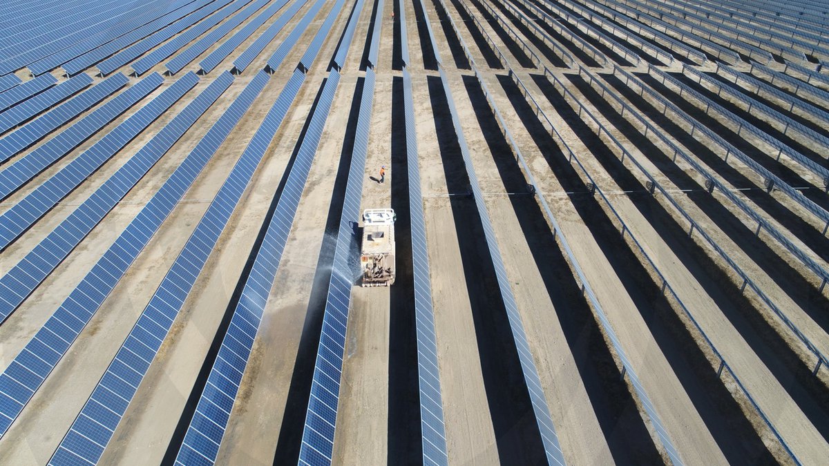 Solar panels being cleaned in preparation for the project to be commissioned.